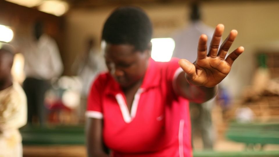 african woman praying with a outstretched hand from lightstock compressor
