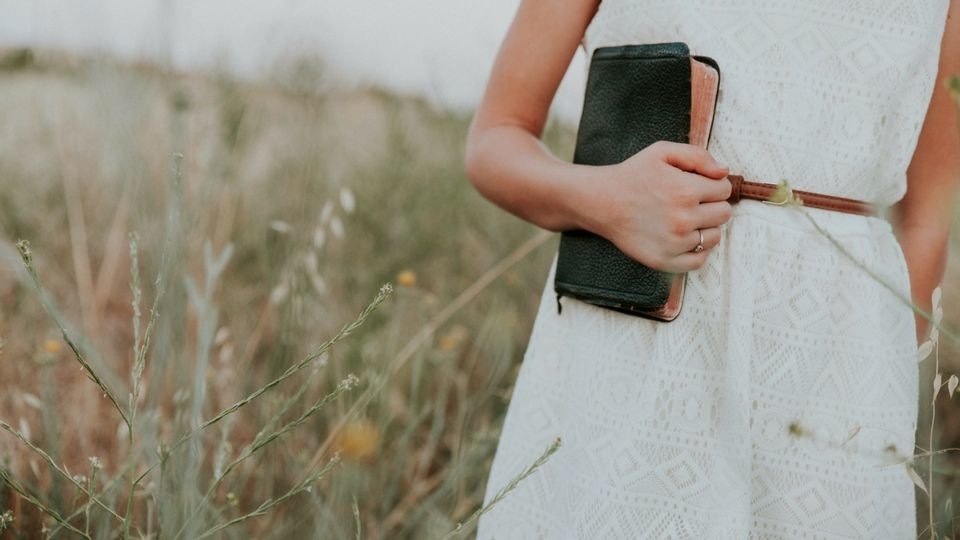 woman holding bible from unsplash compressor